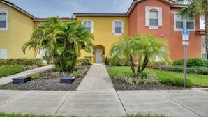 A yellow building with a red roof, a parking sign, and a wheelchair accessibility sign. - Near Disney & Epic Universe: Home w/ Resort Perks (Kissimmee)