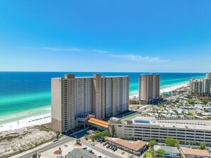 Ein Hochhaus-Hotel mit mehreren Etagen, einer Tiefgarage und Blick auf den Strand.
