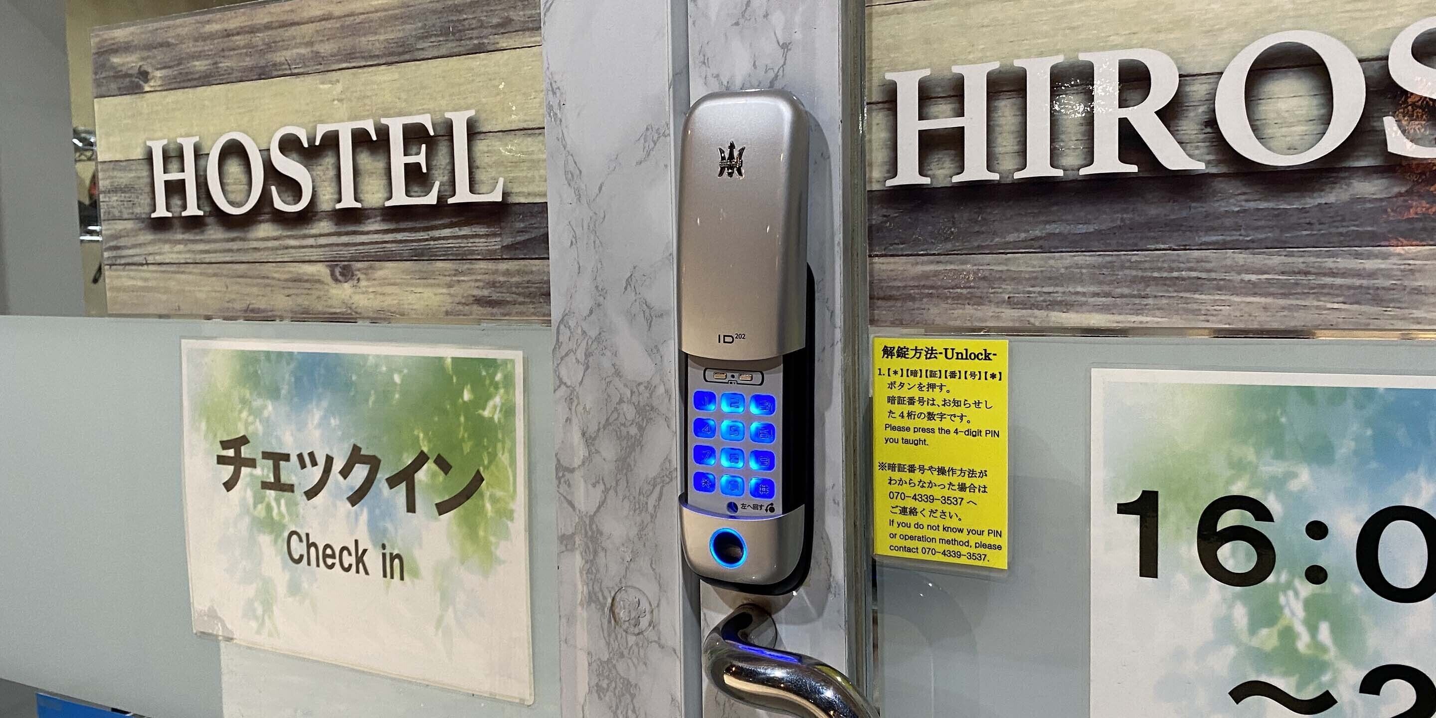 A hotel room with a check-in sign, a digital keypad for room access, and a sign indicating the room number.