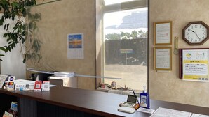 A reception desk with a clock, framed certificates, and a calendar. - Hostel Hirosaki - Hostel (Hirosaki)