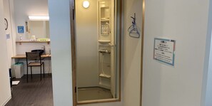 A hotel bathroom with a shower, a sink, and a mirror. There is a sign on the wall with instructions. - Hostel Hirosaki - Hostel (Hirosaki)