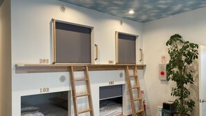 A room with bunk beds, numbered from 101 to 202, wooden ladders, a plant, a fire extinguisher, and a no-smoking sign. - Hostel Hirosaki - Hostel (Hirosaki)