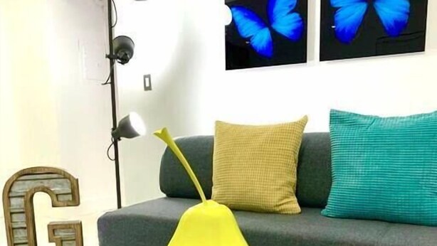 A living room with a sofa, a yellow vase, and a letter 'G' on a table. - THE GROVE 6    10 MIN FROM THE BEACH In the heart of Coconut Grove and CocoWalk (Miami)