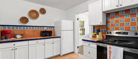 A kitchen with white cabinets, a stainless steel stove, and a microwave.