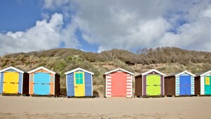 A row of beach huts with a sandy beach and dunes in the background. - Cutterbrough, Great Field Lodges -  a lodge that sleeps 2 guests  in 1 bedroom (Braunton)