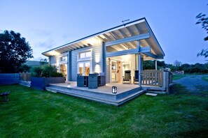 A modern house with a covered porch, a patio, and a well-maintained lawn. - Swanpool, Great Field Lodges -  a lodge that sleeps 2 guests  in 1 bedroom (Braunton)