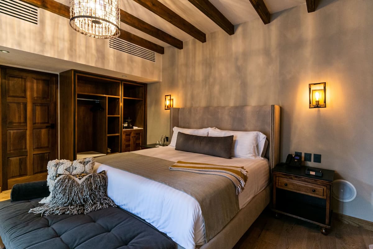 Une chambre à coucher avec un grand lit, une armoire en bois et une table de chevet avec une lampe.