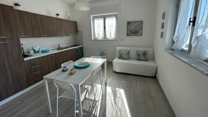 Una cocina moderna con armarios de madera, una mesa de comedor blanca y un sofá blanco.