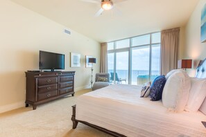Une chambre d’hôtel avec un grand lit, une télévision, une commode et un balcon avec vue.