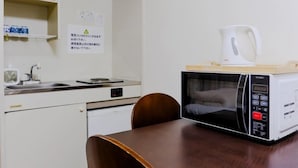 A compact kitchenette with a microwave, a coffee maker, and a small refrigerator. - Hotel Hill top (Tokyo)