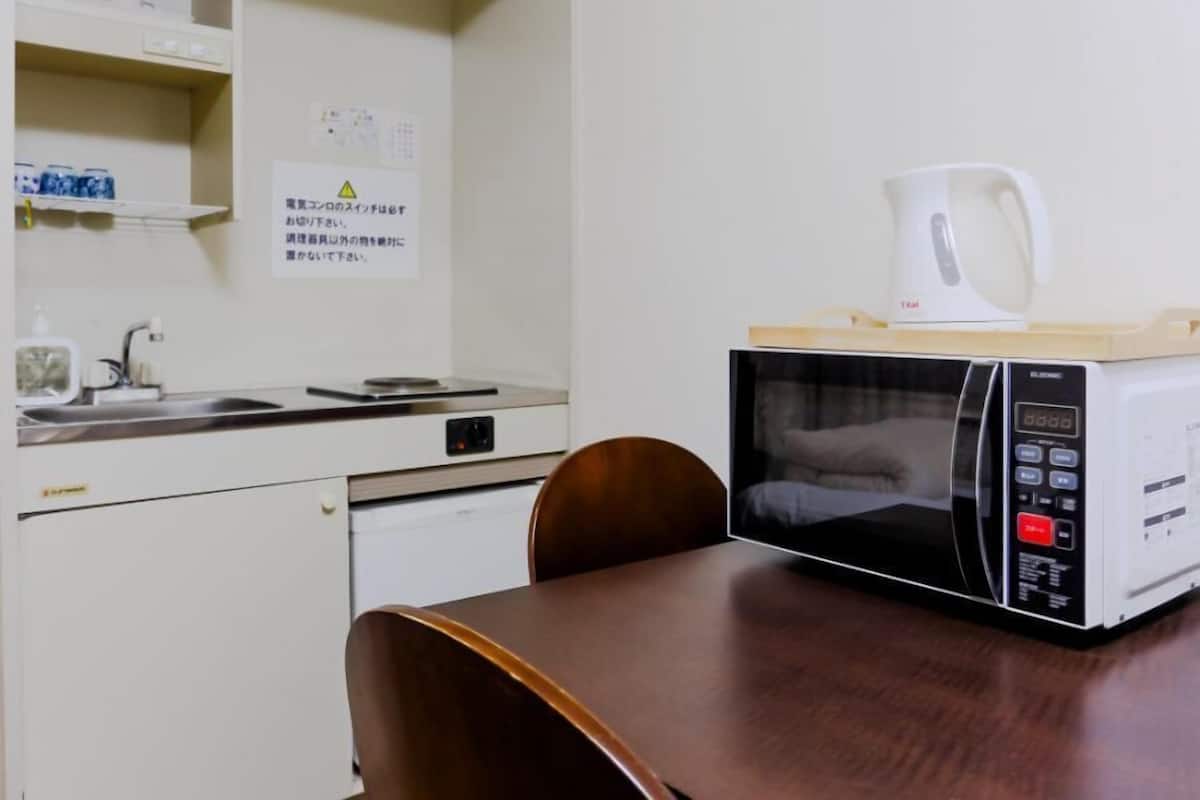 A compact kitchenette with a microwave, a coffee maker, and a small refrigerator.