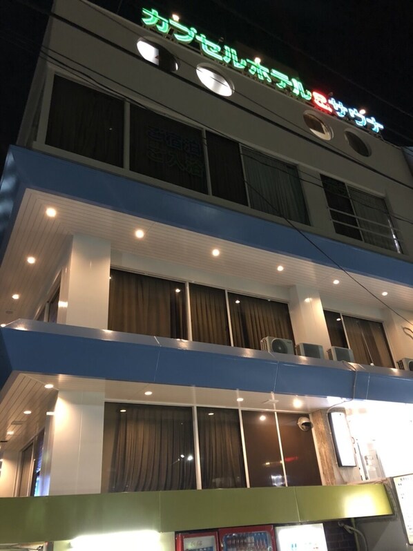 A multi-story hotel with illuminated signage and multiple balconies.