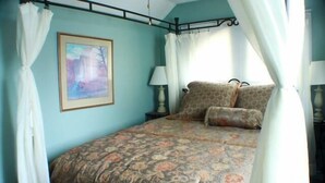 A bedroom with a bed, a nightstand, a lamp, and a painting on the wall. - Sugar Ski & Country Club Unit 11-803 Silver (Banner Elk)