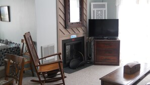 A living room with a fireplace, a television, and a rocking chair. - Sugar Ski & Country Club Unit 11-803 Silver (Banner Elk)