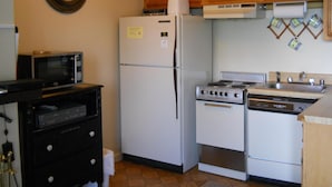 A compact kitchen with a refrigerator, microwave, stove, and sink. - Sugar Ski & Country Club Unit 113 Bronze (Banner Elk)