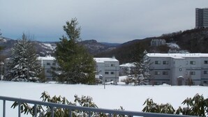 A residential area with snow-covered ground, a few buildings, and a mountainous backdrop. - Sugar Ski & Country Club Unit 113 Bronze (Banner Elk)