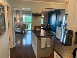 A modern kitchen with a central island, a dining area with a chandelier, and a view of the outdoors. - Sugar Ski & Country Club Unit 411 Bronze (Banner Elk)