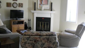 A living room with a fireplace, a television, and a sofa. - Sugar Ski & Country Club Unit 413 Silver (Banner Elk)