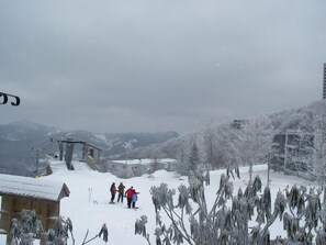 Eine verschneite Berglandschaft mit einer Seilbahn, einer Holzhütte und einem Gebäude mit einem mit Schnee bedeckten Dach.