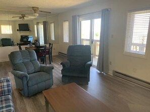 A spacious living room with a ceiling fan, a dining area with a table and chairs, and a view through a sliding glass door to the outdoors. - Sugar Ski & Country Club Unit 416 Bronze (Banner Elk)
