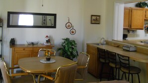 A kitchen with a dining table, chairs, a ceiling fan, a sink, and wooden cabinets. - Sugar Ski & Country Club Unit 421 Bronze (Banner Elk)