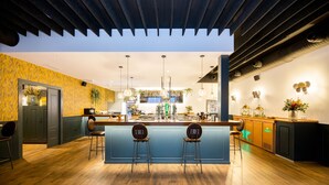 Una cocina moderna con una isla central, taburetes de bar e iluminación colgante.