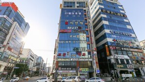 A multi-story commercial building with various businesses, including a visible M.V.P sign. - The Way Hotel (Changwon)