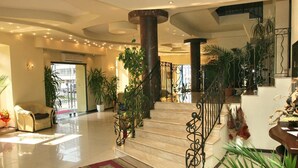 A spacious lobby with a marble staircase, potted plants, and a red carpet. - Charlino Plaza (Ruse)
