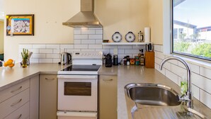 Une cuisine moderne équipée d’un four encastré, d’une cuisinière et d’un évier en acier inoxydable.