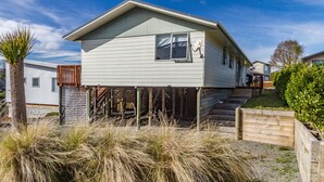 Une maison de plain-pied avec une terrasse à l’avant et une antenne parabolique.