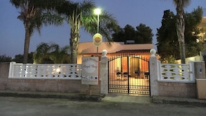 A gated entrance to a property named 'Bed & Breakfast Angel Bay' with a signboard and a website URL.