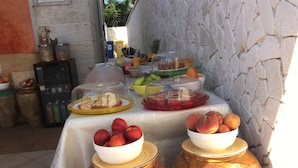 A buffet table with various food items, including jars of preserved fruits and covered dishes.
