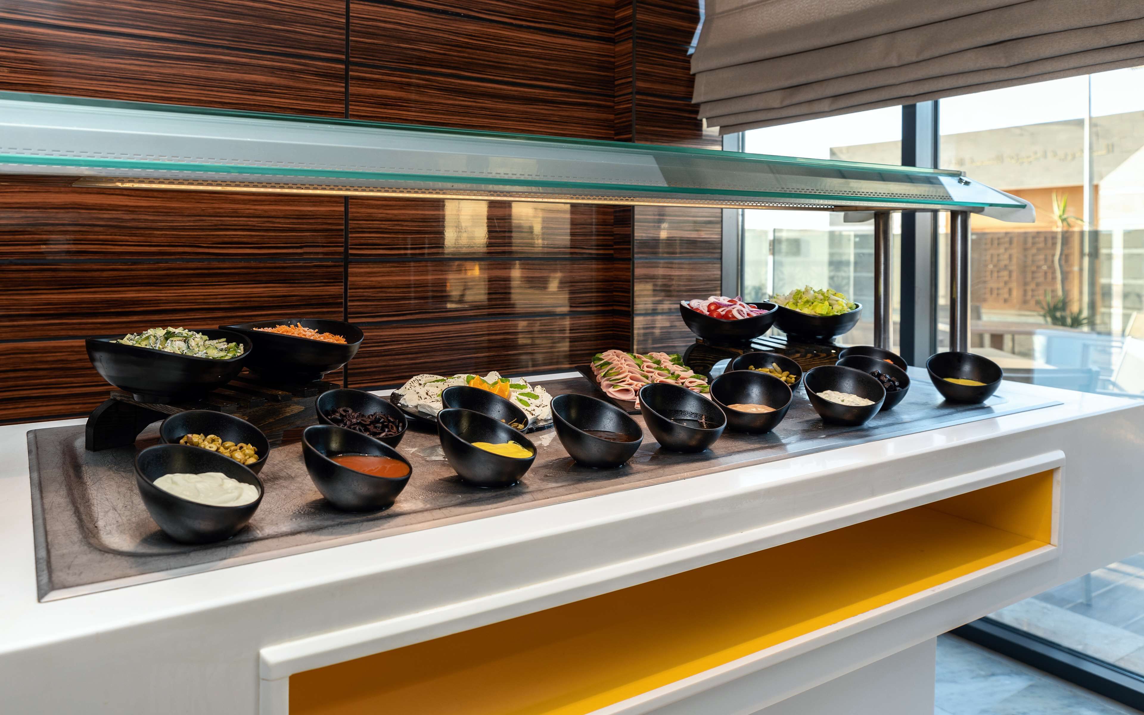 A buffet setup with various dishes and condiments.