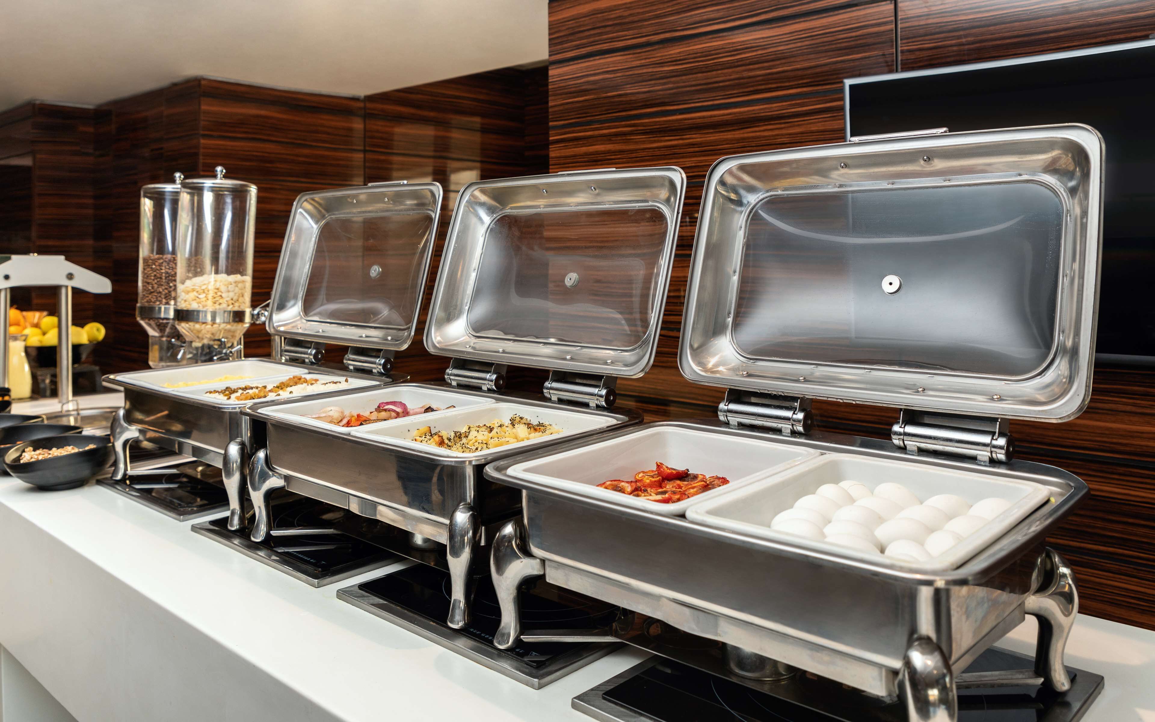 Una mesa de buffet con múltiples dispensadores de comida y una estación de bebidas.