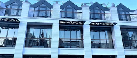A modern building with multiple balconies, large windows, and a sign reading "MIYAS LUXURY".