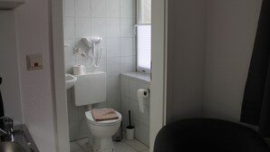 A small, compact bathroom with a toilet, sink, and a window.