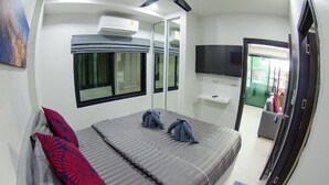 A hotel room with a bed, a TV, a mirror, and a window. - The Elegance Pool Villas at KP Beach (Ko Chang)
