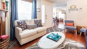 A living room with a sofa, armchairs, a coffee table, and a dining area in the background. - Community Pool!  12 Minutes to Beach & Downtown Charleston.  Comfortable Family-Friendly Townhome. (Mount Pleasant)