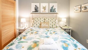 A bedroom with a bed, a headboard with a 'Relax' pillow, two bedside tables with lamps, and framed pictures on the wall. - Community Pool!  12 Minutes to Beach & Downtown Charleston.  Comfortable Family-Friendly Townhome. (Mount Pleasant)