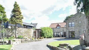 A stone building with a red-tiled roof, a gravel driveway, and a stone wall. - The Coach House at Mount Pleasant (Heighington, near Darlington)