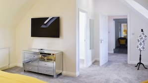 A bedroom with a bed, a dresser, a TV, and a mannequin. - The Coach House at Mount Pleasant (Heighington, near Darlington)