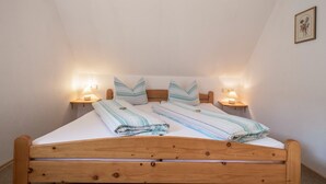 Een slaapkamer met een houten bed, twee bedlampen en een ingelijste foto aan de muur.