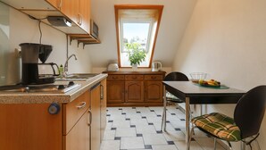 Une cuisine avec des meubles en bois, une machine à café, un évier et une fenêtre donnant sur un beau paysage.