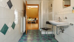 Une salle de bain avec un lavabo, un miroir et une douche.