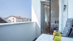 Un balcón con una mesa, un tarro de vidrio y vistas a edificios.