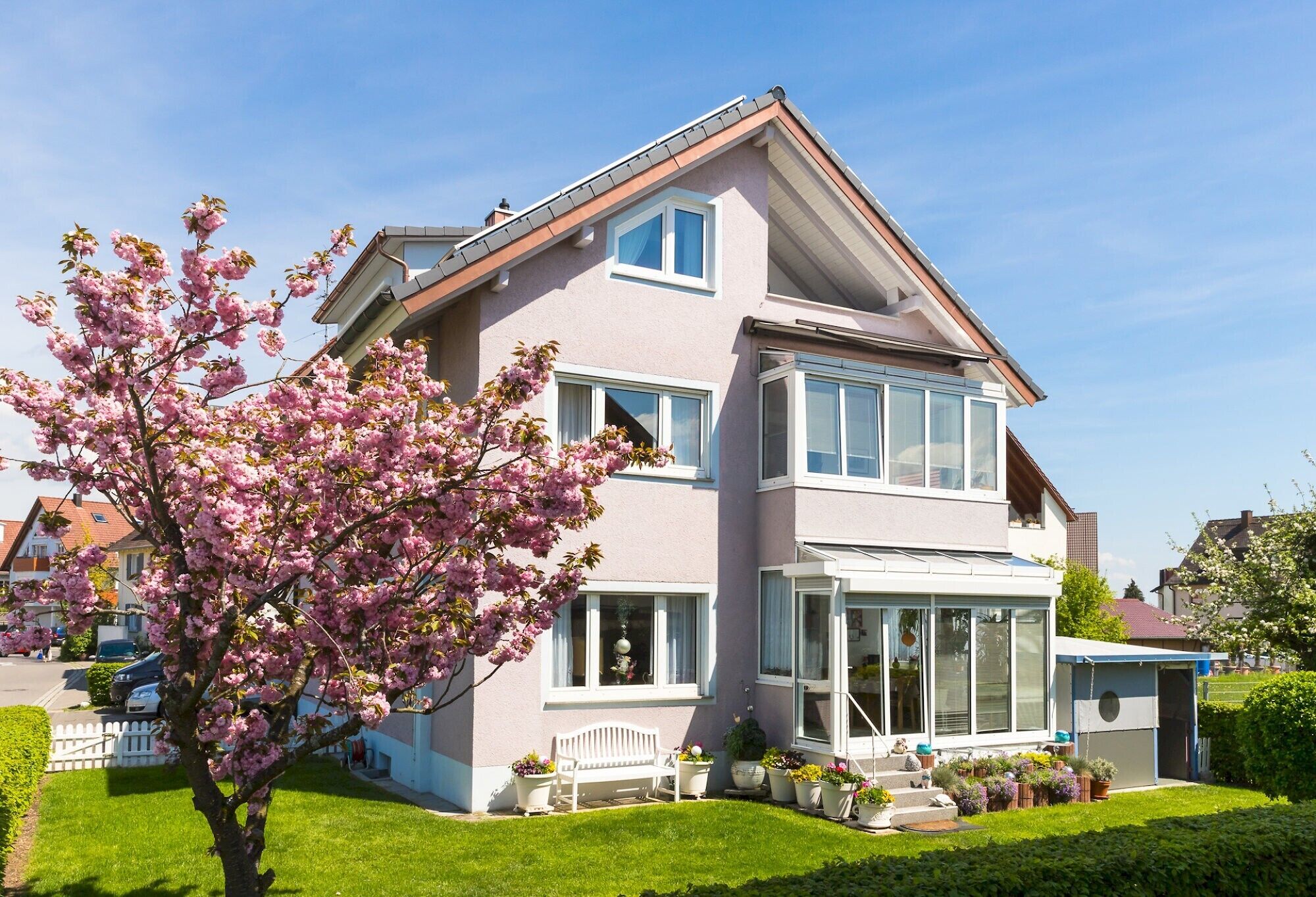 A two-story house with a balcony and a garden.