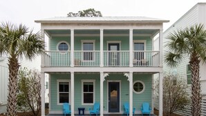Een huis met twee verdiepingen, een balkon en een veranda met stoelen, en het nummer '427' op de voordeur.