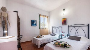 A room with two beds, a desk, a chair, a lamp, and a statue. - Cosy Holiday Home "Casa Sabina" in Alcalá with Terrace, Sea Access and Garden (Gu ía de Isora)