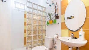 Une salle de bain avec des toilettes, un lavabo et une fenêtre donnant sur un paysage agréable.