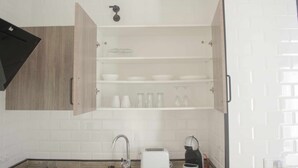 A kitchen with a built-in dishwasher, a sink, a toaster, and a coffee machine.